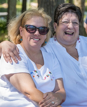 Two women sitting on a bench and laughing