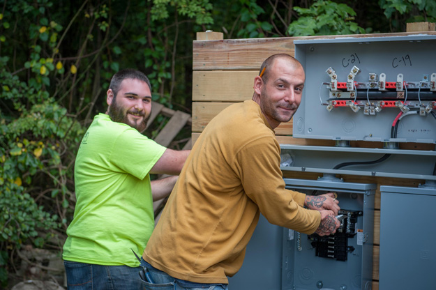 Two workers inslatting an electrical panel at Exeter-Hampton Cooperative.