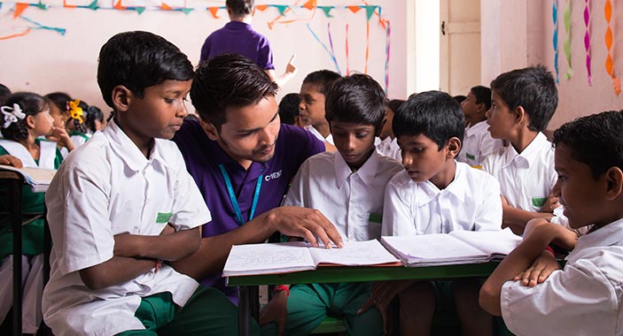 Volunteers With Students Of An Adopted School