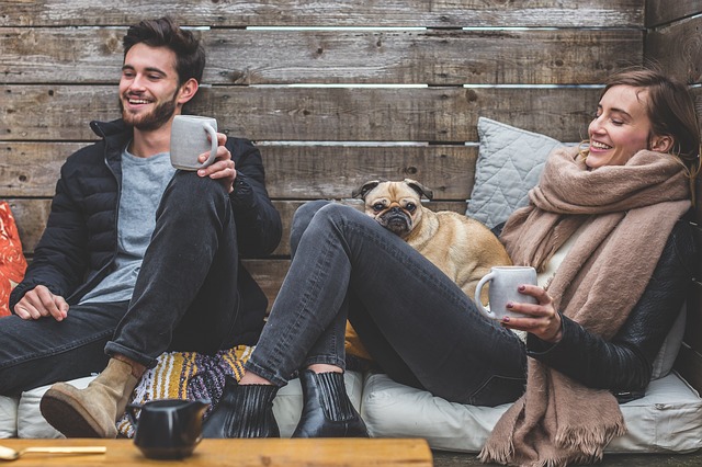 Image of a man and woman on a bench with a dog and cup of coffee - 7 ways to explain anxiety to a partner - genomind
