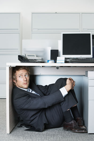 business-man-hiding-under-desk.jpg