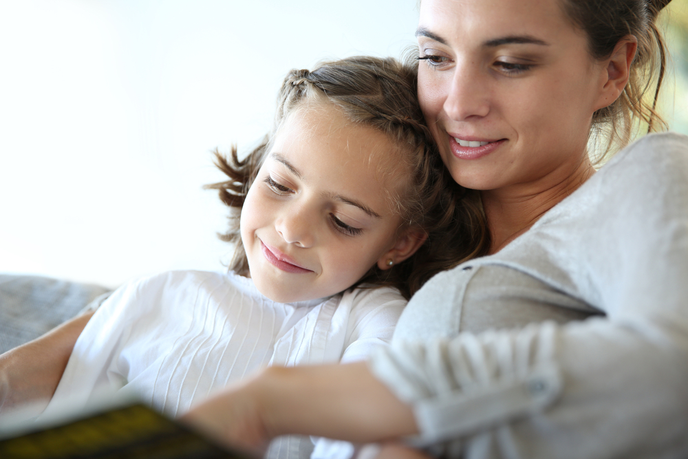 Mom with little girl reading book in sofa-1