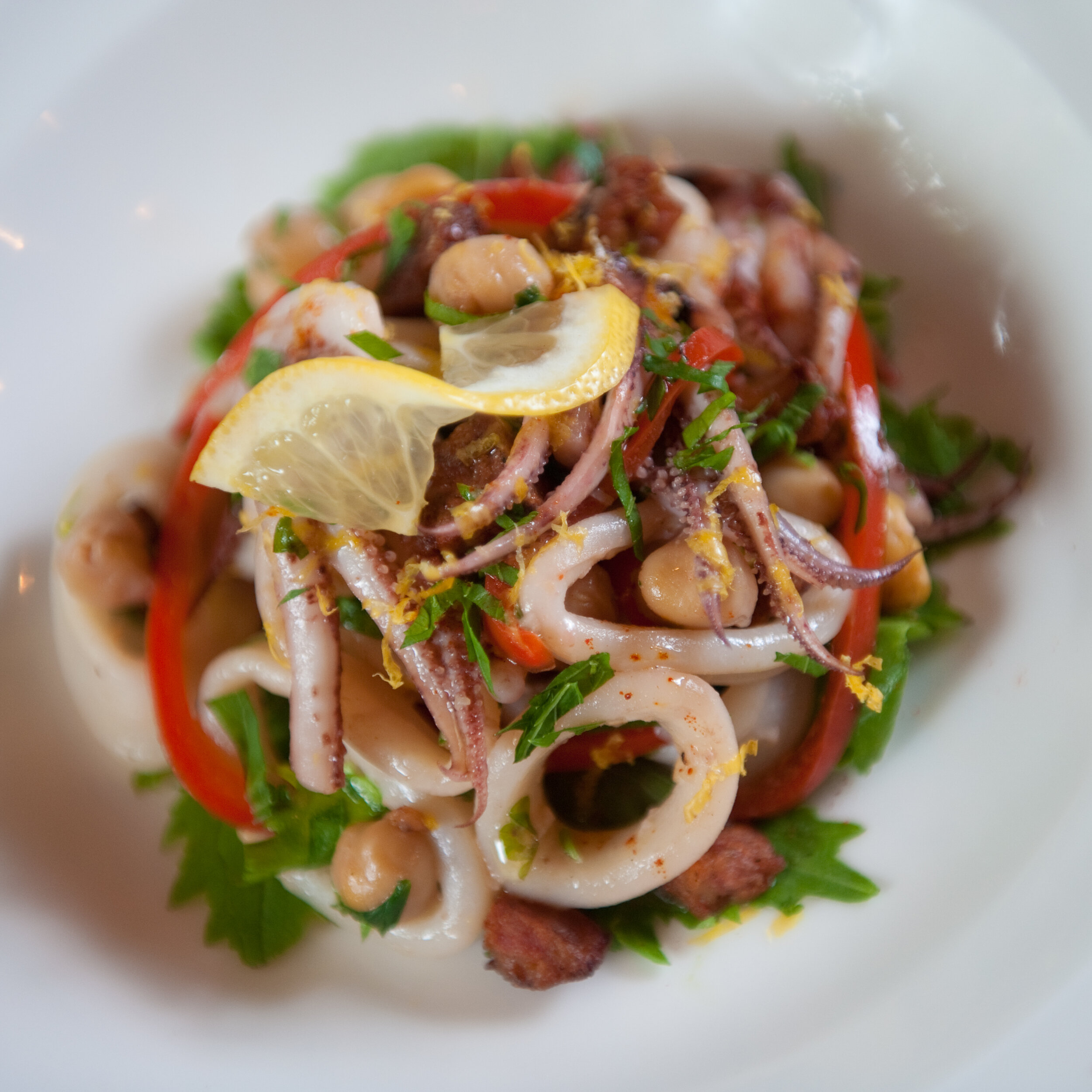 Dish of calamari with parsley and lemon