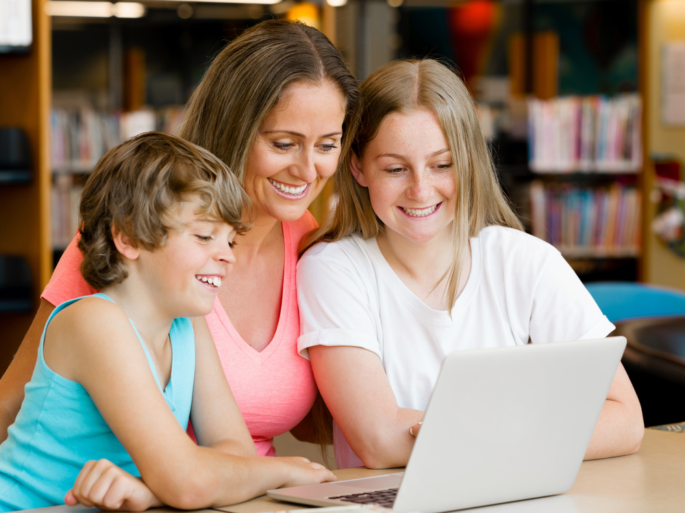 Mother with kids in library with notebook