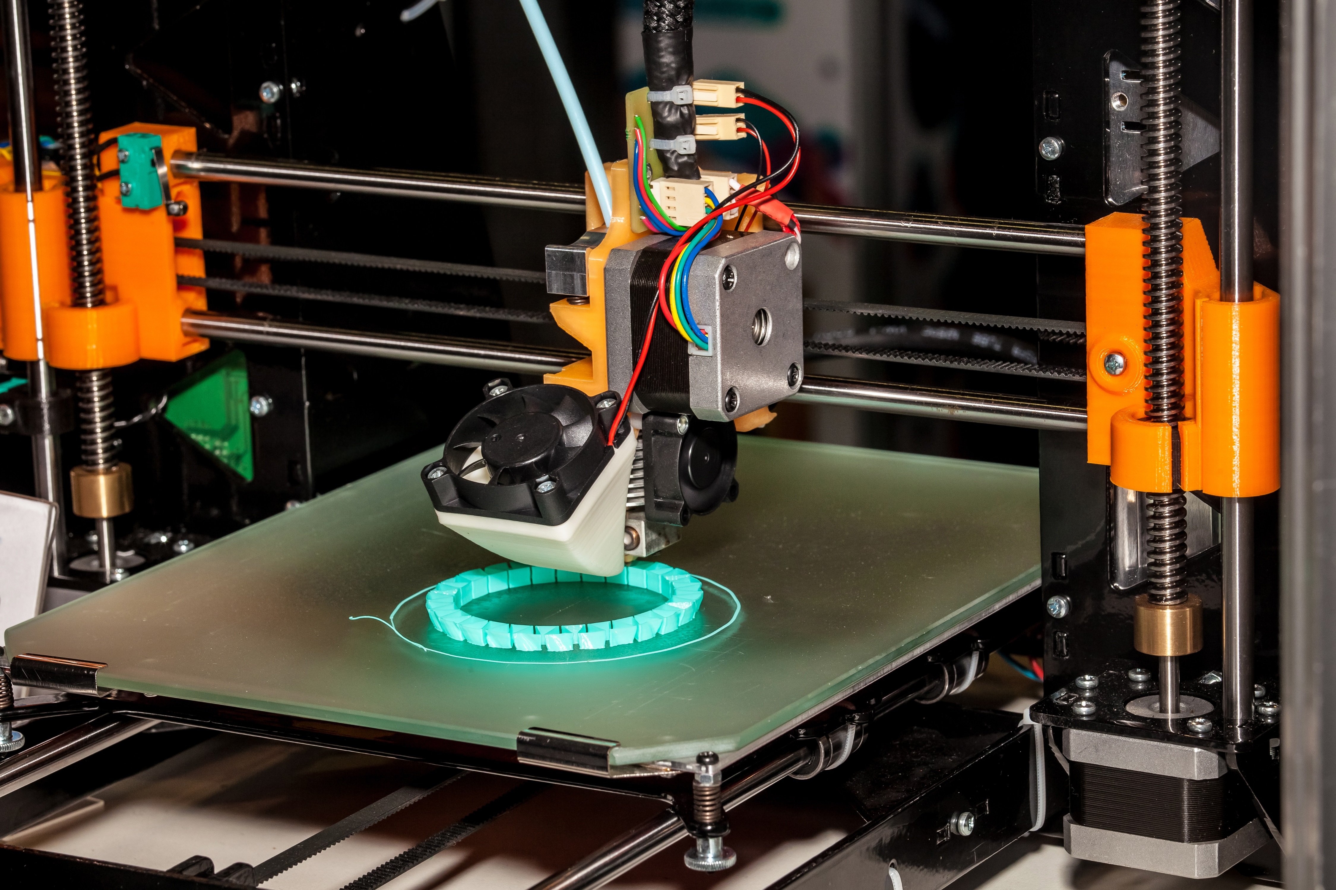 A material extrusion-type 3D printer at work printing a circular object.