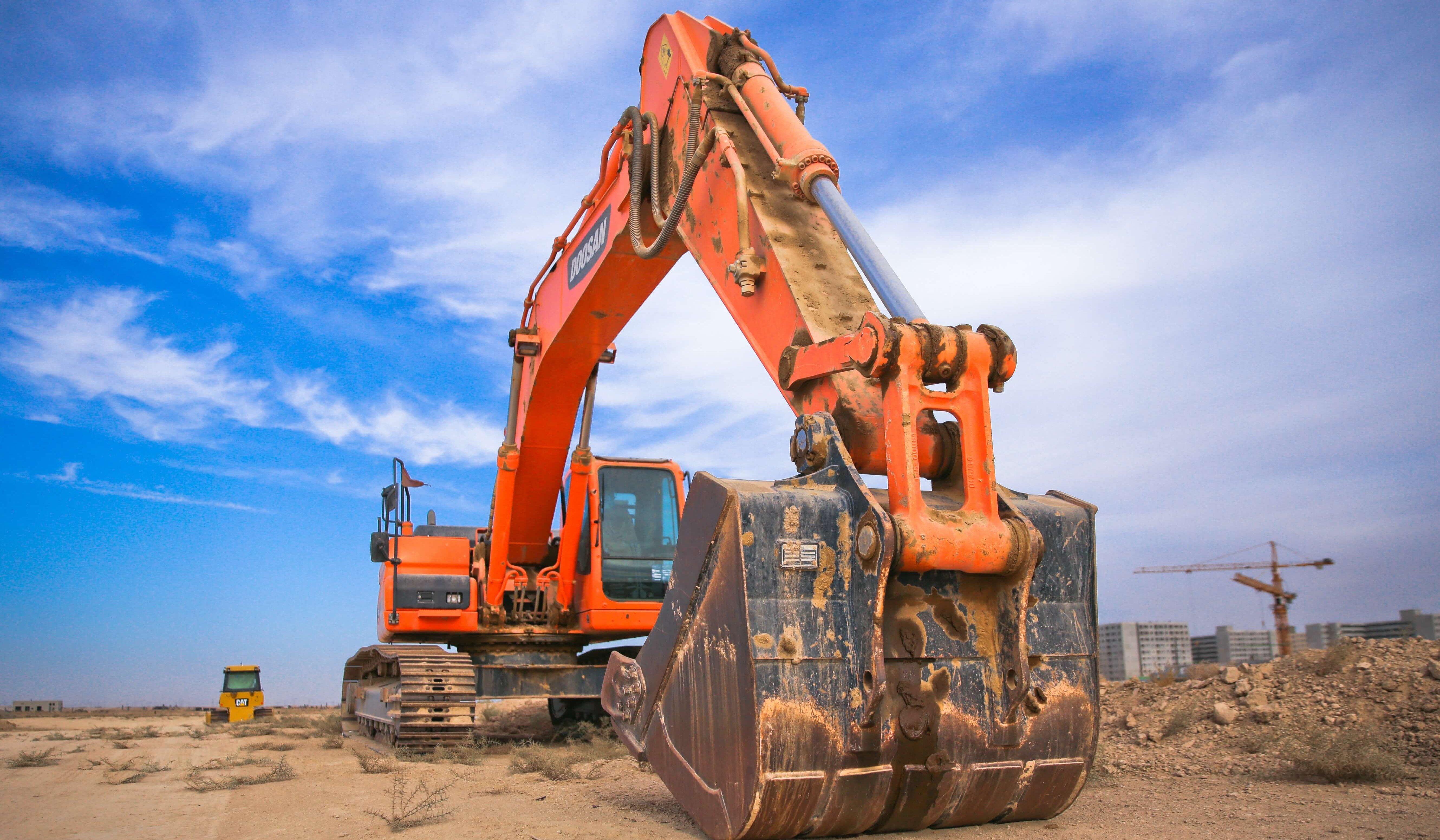 low-angle-photography-of-orange-excavator-under-white-clouds-1078884 (1)