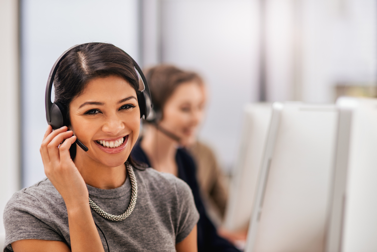 IT-professional-with-headset-smiling-while-talking-to-customer-remotely